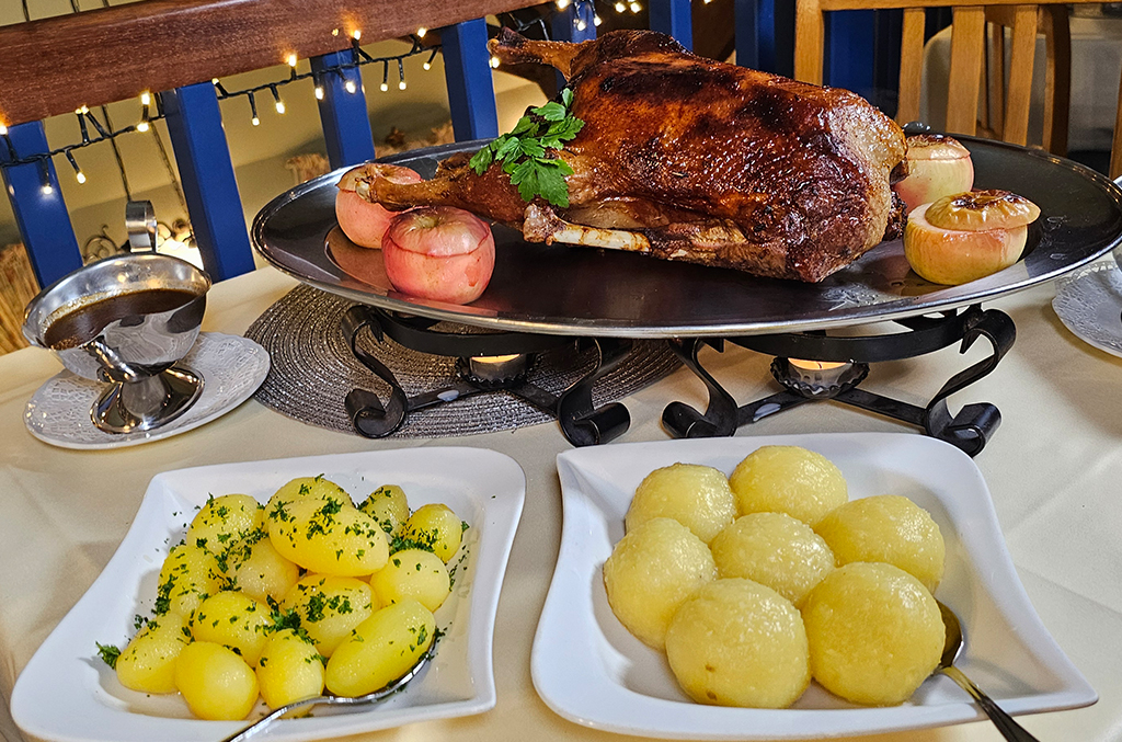 Ganze Gans mit Beilagen wie Rotkohl, Klößen und Bratäpfeln